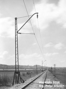 eingleisige gerade Strecke mit Oberleitung an Stahlmasten mit Schrägausleger und zwei Vollkernisolatoren in Reihe